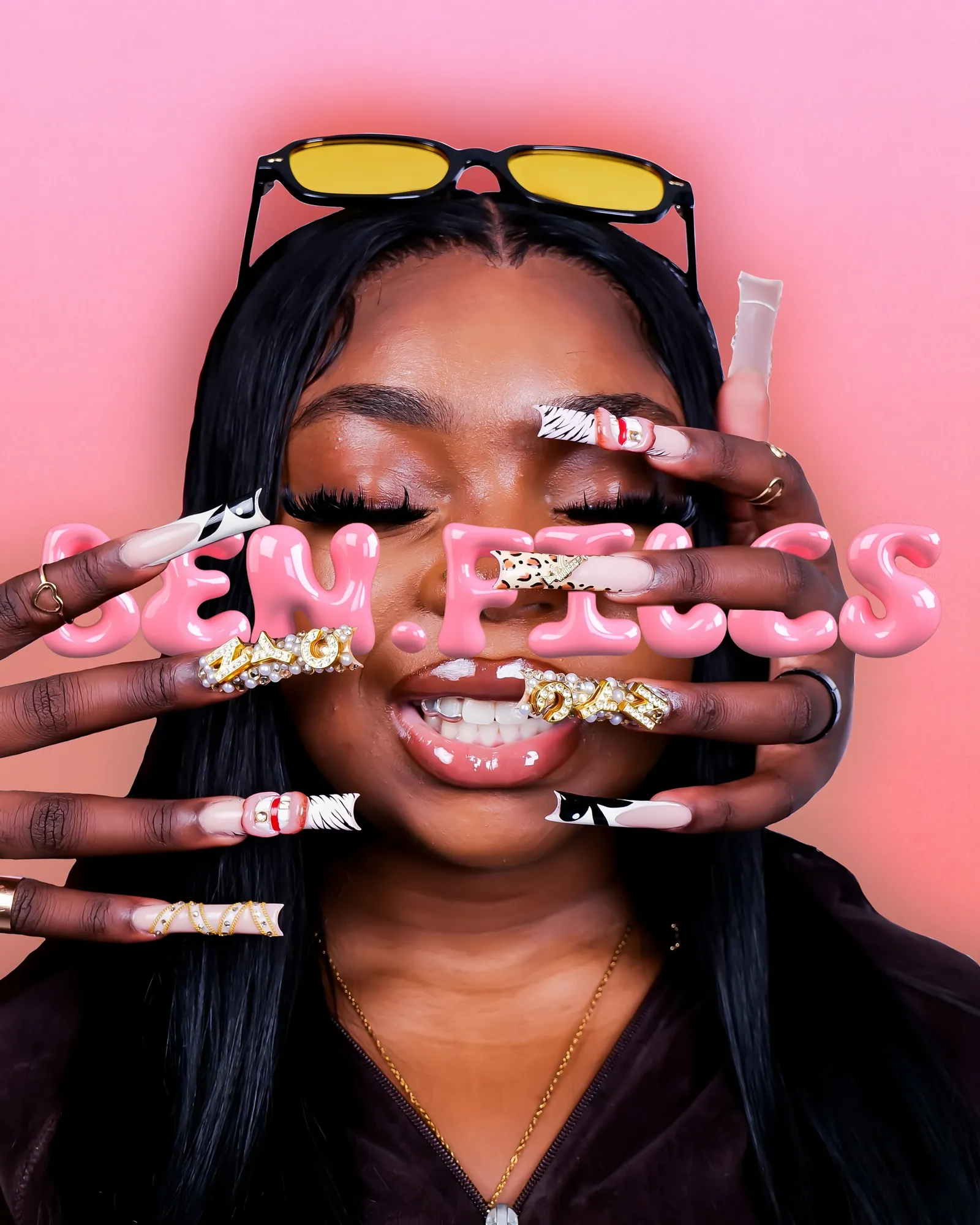 A smiling woman with yellow sunglasses on her head and long decorated nails over her face, bubble lettering on pink