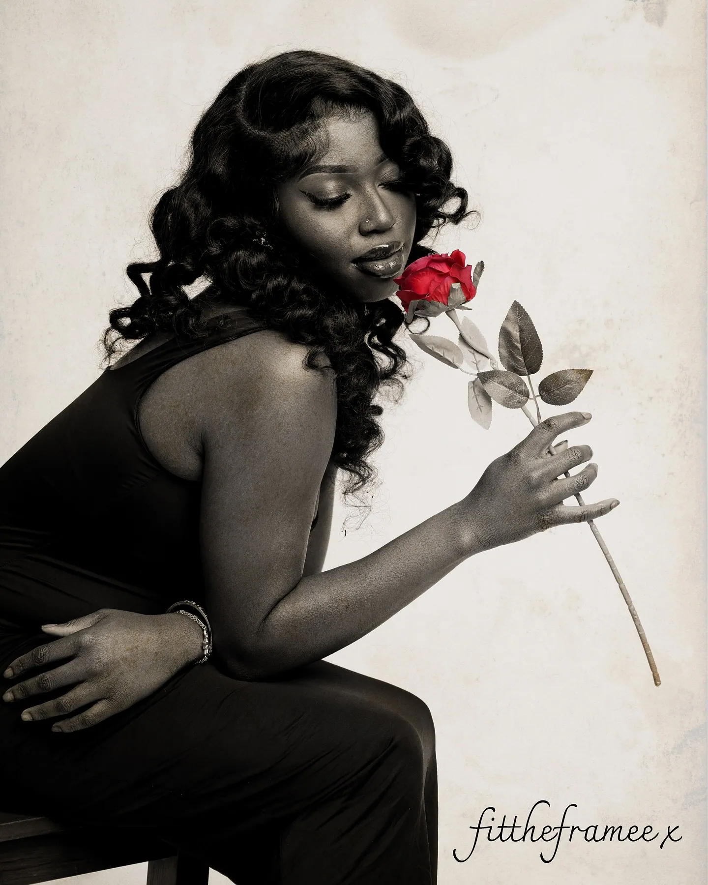 Sepia portrait of a woman in black smelling a red rose, with a handwritten fittheframee signature in the corner